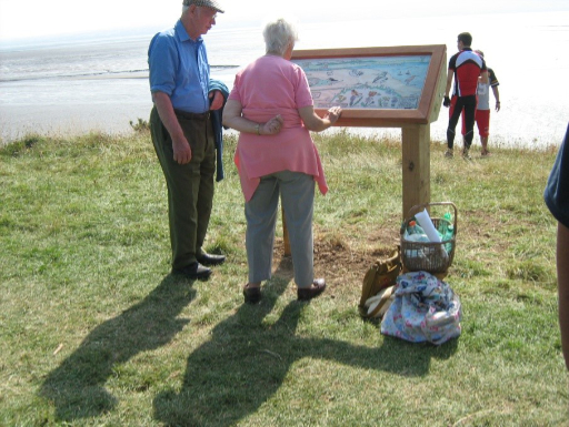 Image of people reading our installed information board at Wirral Country park, Thurstaston